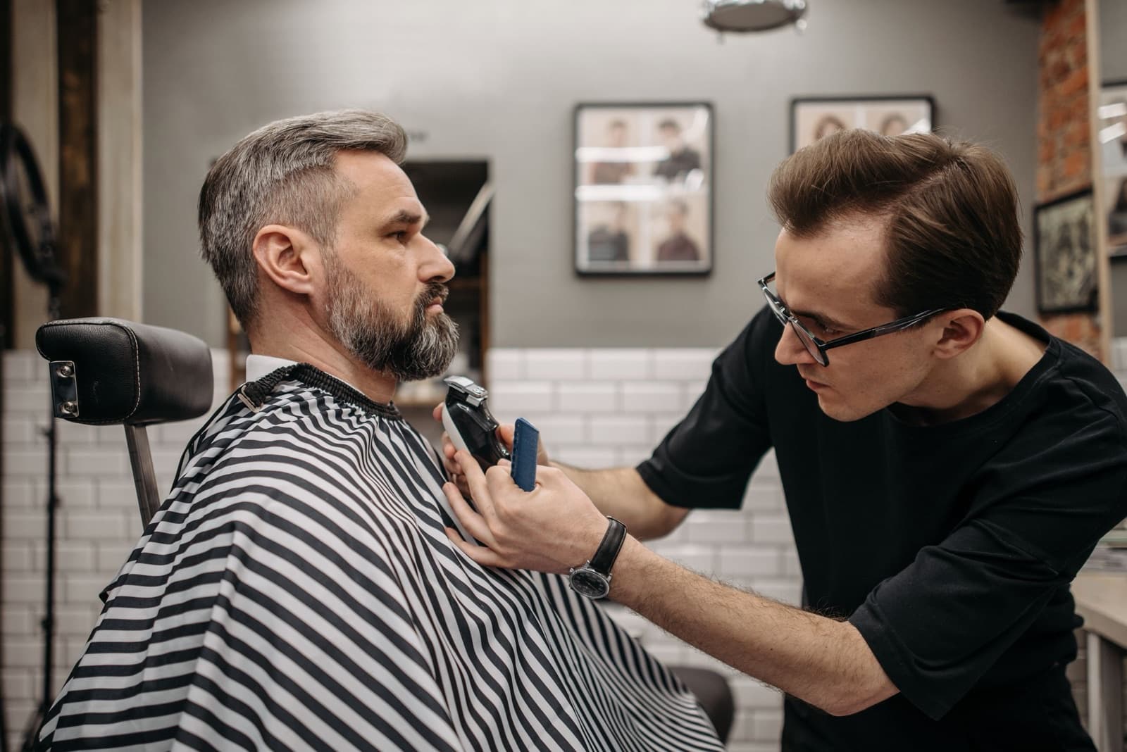 Barbier trimmt einem Kunden den Bart